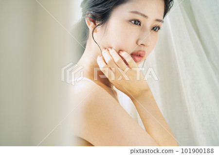 Beauty portrait of a beautiful woman standing by the window 101900188