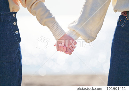 好年輕女人和朋友在海灘手牽手 好年輕女人和朋友在海灘手牽手 101901431