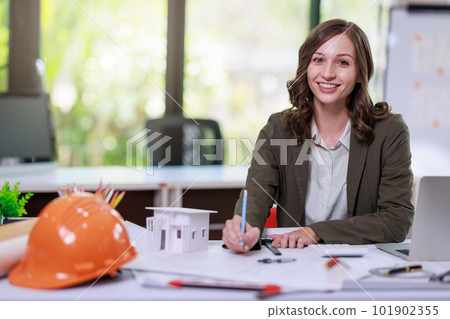 Construction concept of Engineer and Architect working with Construction model and blueprint before buit at site, Engineer and Architect discussing construction plan with computer laptop calculator 101902355