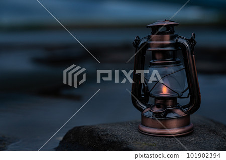 An antique lantern placed near the surface of the water An antique lantern placed near the surface of the water 101902394
