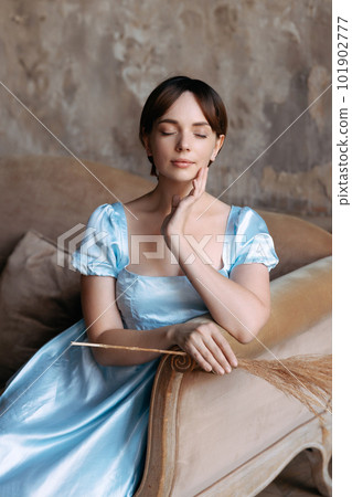 A young beautiful girl in a Regency blue dress 101902777