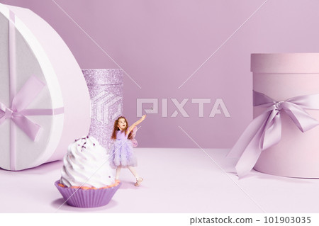 Beautiful little girl in cute dress standing near giant cake and present boxes against violet background Beautiful little girl in cute dress standing near giant cake and present boxes against violet background 101903035