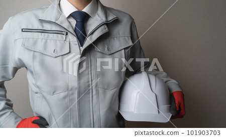 A man in work clothes with a helmet A man in work clothes with a helmet 101903703