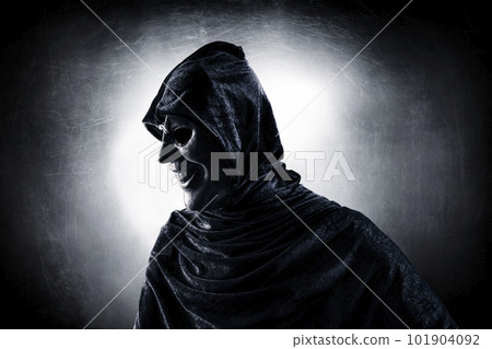 Scary figure with hooded cloak in the dark Scary figure with hooded cloak in the dark 101904092