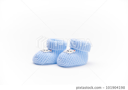A pair of handmade blue knitted baby booties, isolated on white background. Newborn clothing and pregnancy concept. Copy space for advertising text. Fashion. A pair of handmade blue knitted baby booties, isolated on white background. Newborn clothing and pregnancy concept. Copy space for advertising text. Fashion. 101904198