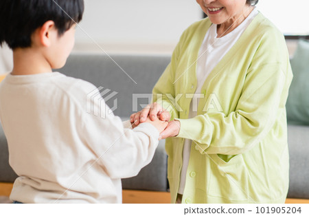 Grandma and grandchildren spending time in the living room 101905204