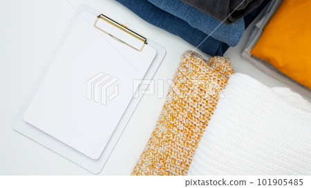 Reduce and reuse concept. Preparing clothes for swap. Waste problem in fashion industry. Vertical storage of clothing, tidying up, garments declutter and sorting. Top view.  Copy spase 101905485