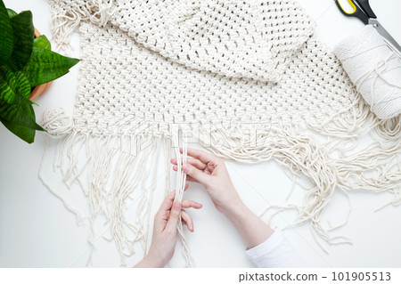 Creative hobby handmade macrame for home decoration. Girl weaves macrame. Woman weaving macrame panels for home decor. Flat lay, top view Creative hobby handmade macrame for home decoration. Girl weaves macrame. Woman weaving macrame panels for home decor. Flat lay, top view 101905513