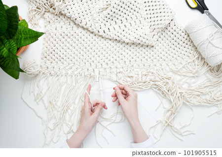Creative hobby handmade macrame for home decoration. Girl weaves macrame. Woman weaving macrame panels for home decor. Flat lay, top view Creative hobby handmade macrame for home decoration. Girl weaves macrame. Woman weaving macrame panels for home decor. Flat lay, top view 101905515
