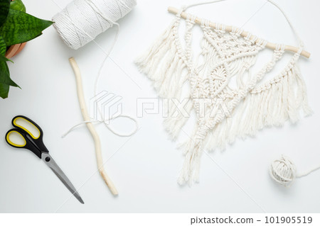 Creative hobby handmade macrame for home decoration. Weaving macrame at home. Tools and materials for macrame weaving. Flat lay, top view Creative hobby handmade macrame for home decoration. Weaving macrame at home. Tools and materials for macrame weaving. Flat lay, top view 101905519