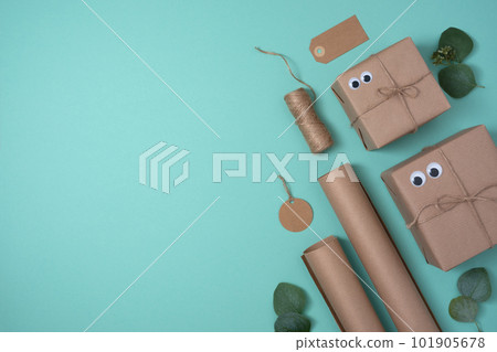 Banner with packaging materials on a turquoise background. Gift box, wrapping paper, gift tags, jute. Copyspace. 101905678