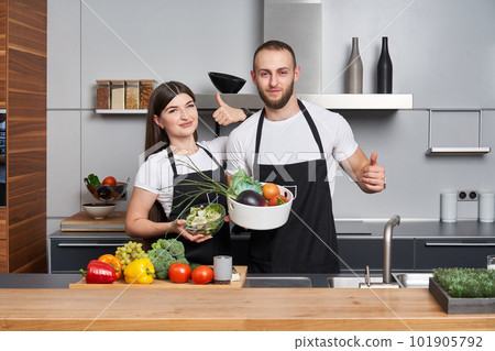 Young couple coocking salad in the kitchen Young couple coocking salad in the kitchen 101905792