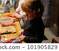 A little boy works in the kitchen, he cuts a tomatoes 101905829