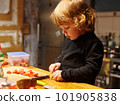 A little boy works in the kitchen, he cuts a tomatoes 101905838