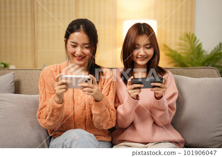 Young woman lesbian couple in sweater sitting on the comfortable Young woman lesbian couple in sweater sitting on the comfortable 101906047