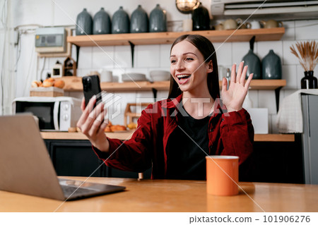 Young businesswoman using smartphone to video conference and gre 101906276