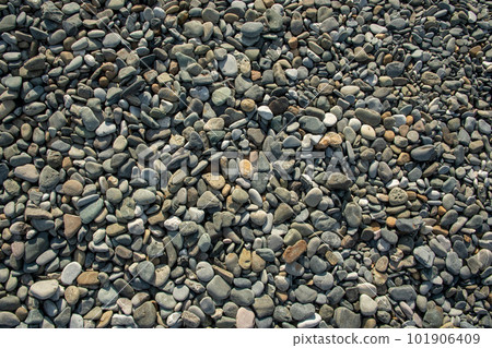 Different color beach stone pebbles at seashore outdoors top view. Abstract smooth round pebbles sea 101906409