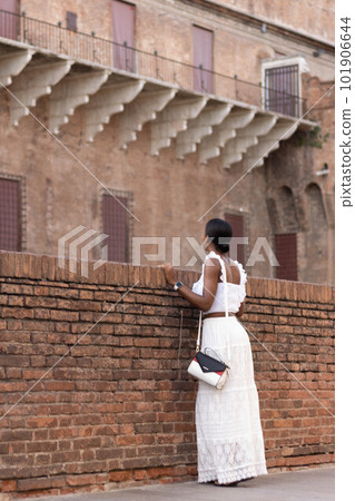 Portrait of turist woman dressed in white getting to know Europe, Ferrara. Italy 101906644