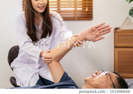 Female physical therapist working and doing arm rehabilitation t 101906689