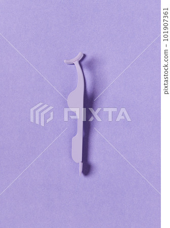 Flat lay top view applicator for false eyelashes on violet background Flat lay top view applicator for false eyelashes on violet background 101907361