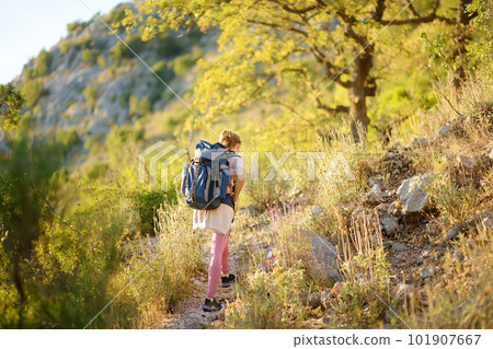 Young woman hiking in countryside. Concepts of adventure, extreme survival, orienteering. Backpacking hike 101907667