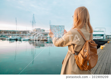 Happy traveler woman with a map and backpack on a lake pier, feeling freedom and enjoying. Travel around Europe. High quality photo Happy traveler woman with a map and backpack on a lake pier, feeling freedom and enjoying. Travel around Europe. High quality photo 101909209