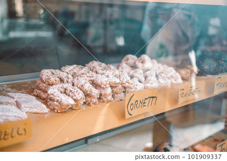 Freshly baked italian croissants (cornetti) on a wooden counter through a store window. Low depth of field Freshly baked italian croissants (cornetti) on a wooden counter through a store window. Low depth of field 101909337