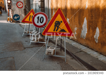 Road works sign on the road. Repair work of road signs and a bypass arrow on a background of blue sky. 101909340