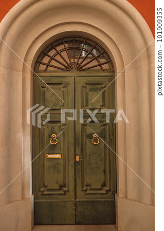 Vintage brown green wooden door with orange wall in Italy Vintage brown green wooden door with orange wall in Italy 101909355