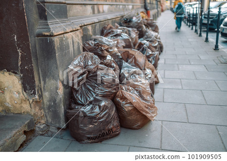 Pile of black garbage on the footpath at side road in big city, pollution trash 101909505