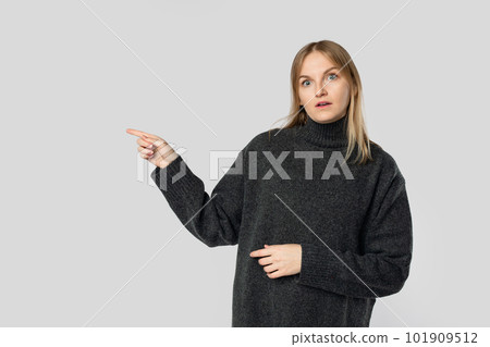 Surprised woman showing point at blank empty copy space isolated on grey studio background Surprised woman showing point at blank empty copy space isolated on grey studio background 101909512