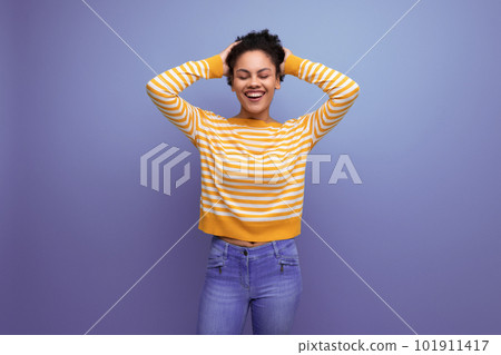 joyful cute brunette curly latin young woman in yellow striped sweater joyful cute brunette curly latin young woman in yellow striped sweater 101911417