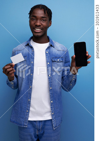 charismatic american man with black dreadlocks making payment with money card and smartphone 101911433