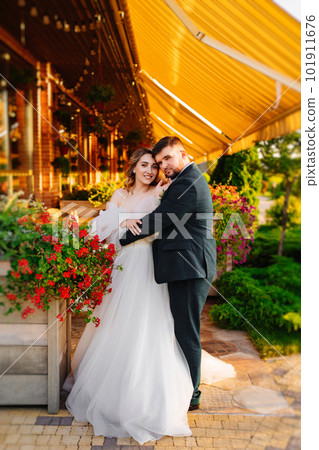 the bride and groom embrace on the terrace in the park near the restaurant. 101911676