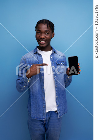 portrait of stylish manager young african man with dreadlocks in denim jacket with smartphone mockup 101911768