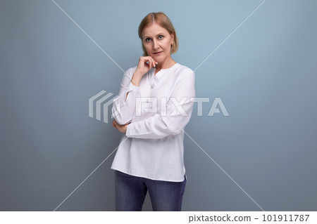 blond hair woman of mature years in a white shirt smiling on a studio background blond hair woman of mature years in a white shirt smiling on a studio background 101911787