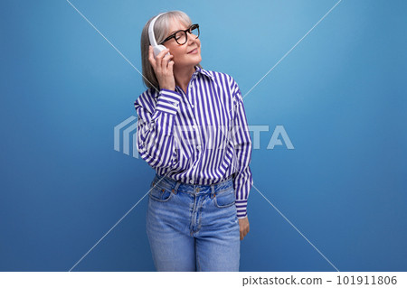 energetic retired woman with gray hair getting acquainted with gadgets for music on a bright studio energetic retired woman with gray hair getting acquainted with gadgets for music on a bright studio 101911806