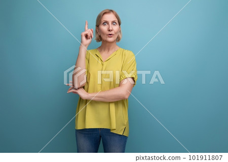thoughtful mature woman demonstrates knowledge on blue background 101911807