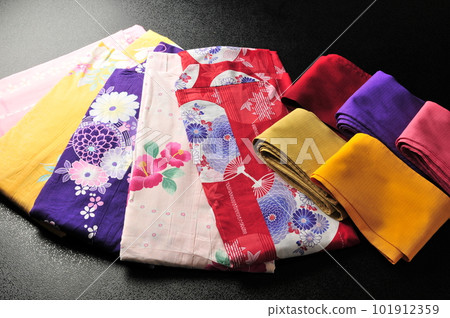 Kimono, colored yukata and obi (women's clothing) black background close-up Kimono, colored yukata and obi (women's clothing) black background close-up 101912359