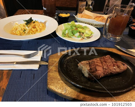 meat and fettuccini with salad over dinner meat and fettuccini with salad over dinner 101912503