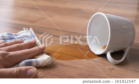 Wiping up spilled coffee on the floor Image Wiping up spilled coffee on the floor Image 101912547