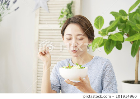 Woman eating salad at home 101914960