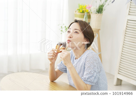 Woman eating donuts at home 101914966