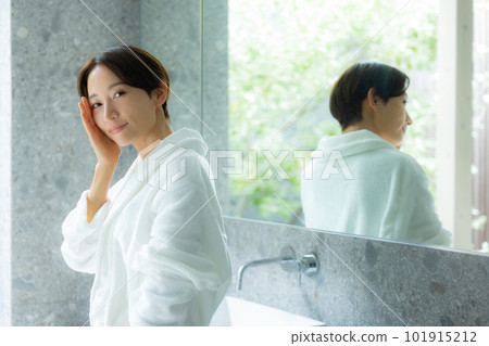 A woman doing skin care in a bathrobe A woman doing skin care in a bathrobe 101915212
