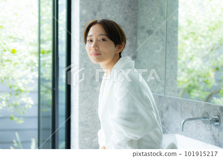 A woman doing skin care in a bathrobe 101915217