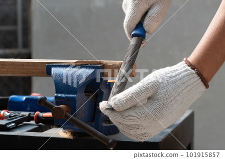 Male hobby retirement. Senior man is using rasp on wood for assembling hammer handle. Male hobby retirement. Senior man is using rasp on wood for assembling hammer handle. 101915857
