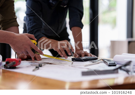 Architect and Engineer working with blueprints for architectural plan, engineer sketching a construction project, green energy concept Architect and Engineer working with blueprints for architectural plan, engineer sketching a construction project, green energy concept 101916248