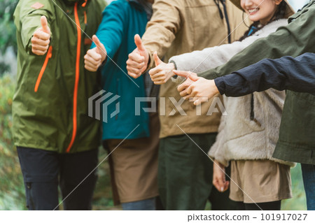在秋冬露營地與朋友團結起來並豎起大拇指的男女（友情、朋友、團隊合作、戶外） 101917027