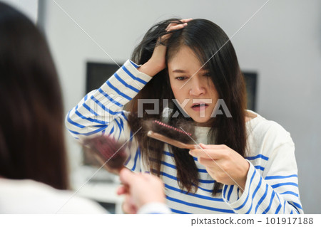 stressed woman suffering hair loss problem with hairbrush in mirror at home stressed woman suffering hair loss problem with hairbrush in mirror at home 101917188