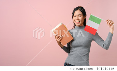Beautiful young Asian woman showing a Italy flag on pink isolated background. 101919546